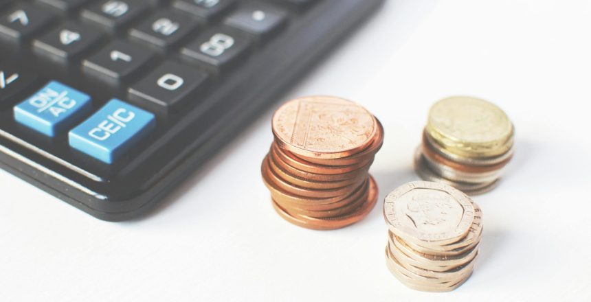 picture of a calculator next to three piles of coins